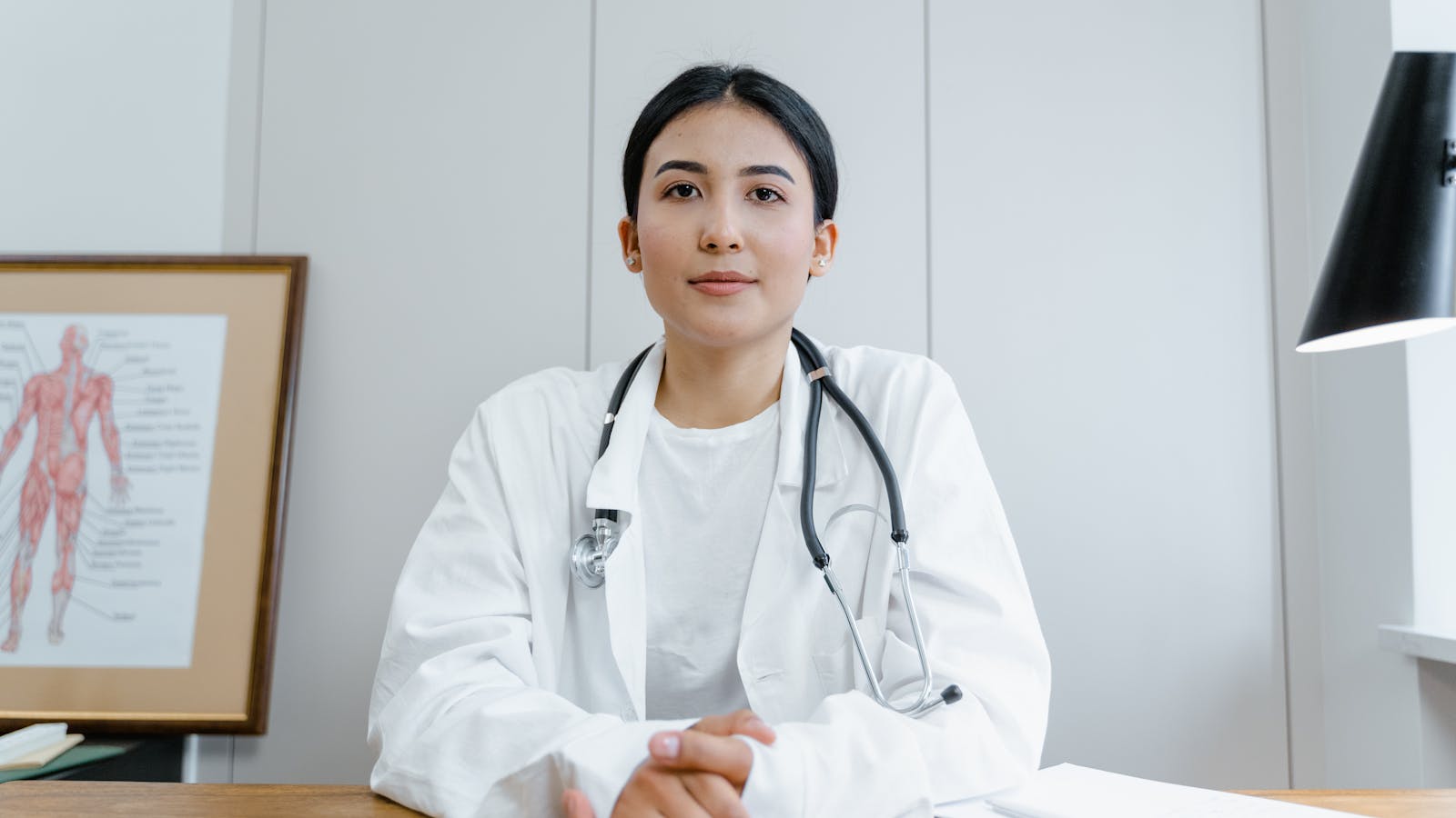 A modern healthcare professional at a clinical desk — clean, contemporary consultation