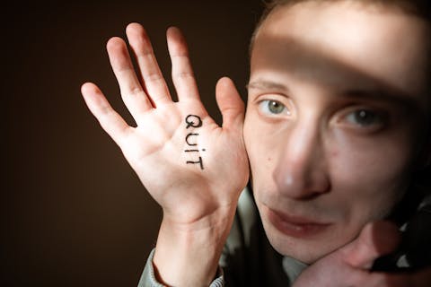 The word 'Quit' written on a palm
